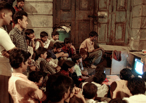 Indian slum dwellers watch the news about the space shuttle Columbia. 