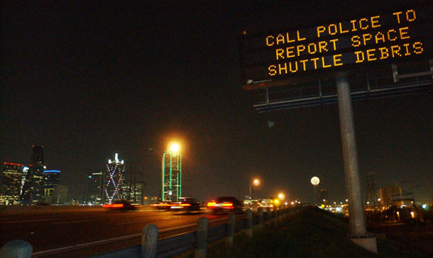 A road sign reads "call police to report space shuttle debris" following the break-up of the space shuttle Columbia. 
