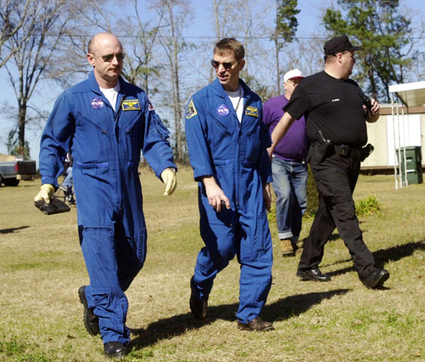 Astronauts Mark Kelly and Greg Johnson carrying debris from the space shuttle Columbia.