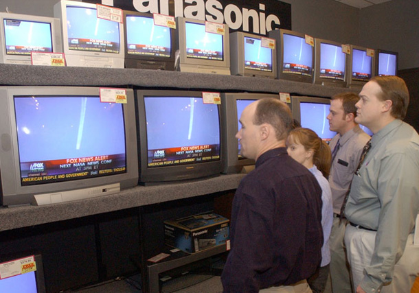 Employees of the John Eye Big Sandy Weekend Superstore watch footage of the space shuttle Columbia disintegrating. 